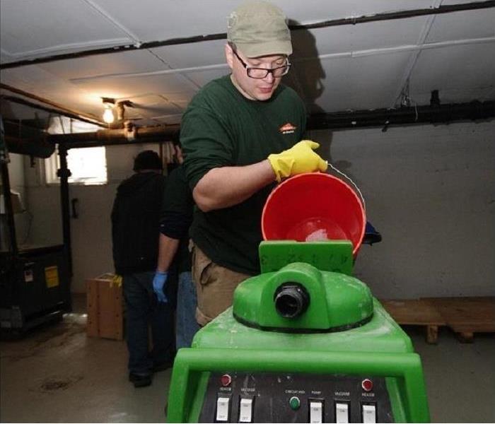 Image shows a product technician preparing SERVPRO equipment to clean floors at a customer's home